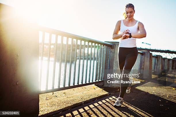 jogging woman checks smart watch - pedometer stock pictures, royalty-free photos & images