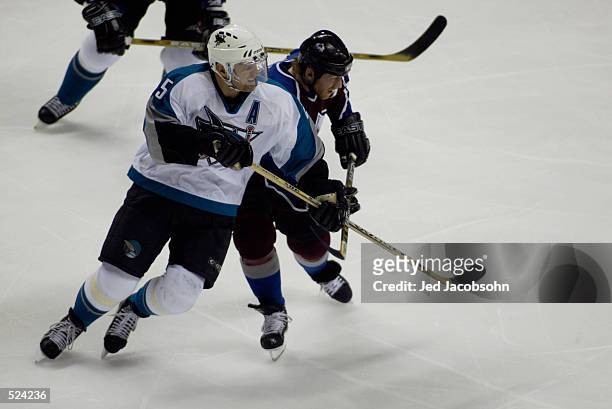 Center Vincent Damphousse of the San Jose Sharks battles with left wing Mike Keane of the Colorado Avalanche during game three of the Stanley Cup...