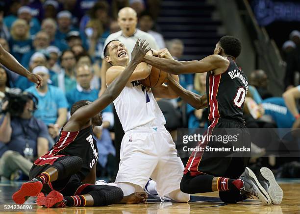 Jeremy Lin of the Charlotte Hornets battles for a loose ball against teammates Luol Deng and Josh Richardson of the Miami Heat during game four of...