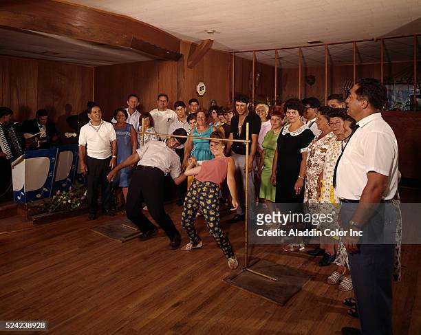 Guests at the Winchelsea Hotel participate in a limbo contest in the lounge. | Location: Palenville, New York, USA.