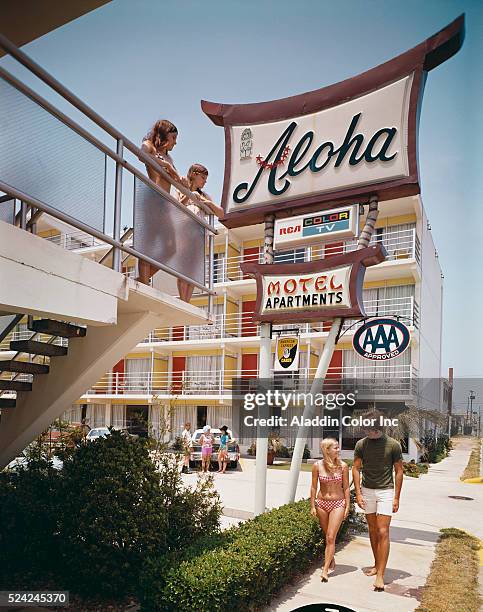 Young couple walks past the Aloha Motel.