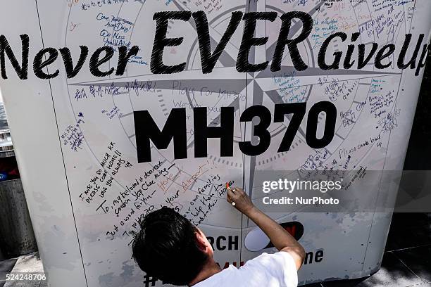 Man writes a message on a board for the missing Malaysian Airlines MH370 during the Day of Remembrance for MH370 in Kuala Lumpur, Malaysia on 8 March...