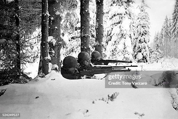 Three US infantrymen in the snow during the Battle of the Bulge, Ardennes, Belgium, World War II, January 1945.