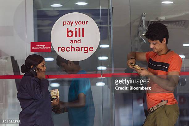 Customers wait to pay their bills at a Bharti Airtel Ltd. Store in New Delhi, India, on Sunday, April 24, 2016. Bharti, India's largest mobile-phone...
