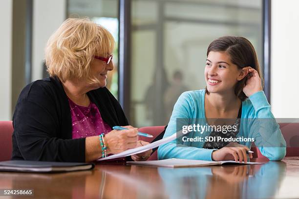 preteen girl meeting with school counselor or therapist - schoolbegeleider stockfoto's en -beelden