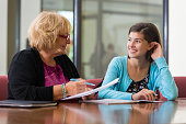 Preteen girl meeting with school counselor or therapist