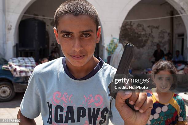 Palestinian boy shows the toy gun he got as Eid present during the celebrations at the parish managed by Archbishop Alexios in Gaza.