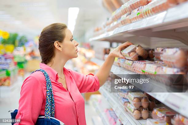 mujer compra de huevos - óvulo fotografías e imágenes de stock