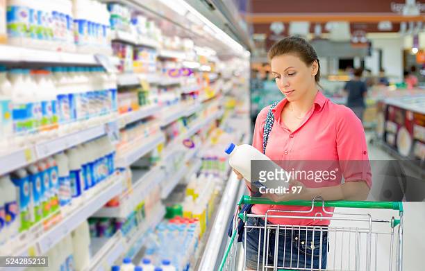 woman buys a milk - milk bottles stock pictures, royalty-free photos & images