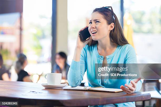 femme contrarié par téléphone au café local - angry customer photos et images de collection