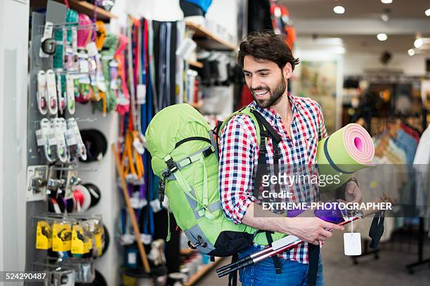 man in the store buying camping equipment - sports equipment stock pictures, royalty-free photos & images