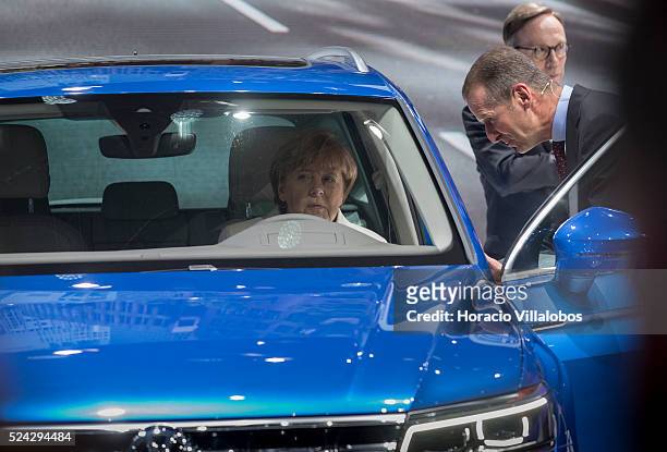 German Chancellor Angela Merkel checks out a Tiguan at Volkwagen's pavilion on the opening day of the 66th International Auto Show, in Frankfurt,...