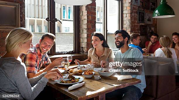 friends enjoying a meal - pub stock pictures, royalty-free photos & images