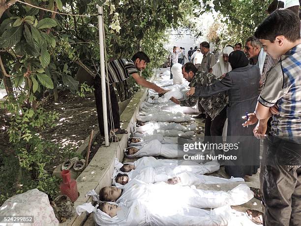 Mother and father weep over their child's body who was killed in a suspected chemical weapons attack on the Damascus suburb of Ghouta, in August 21,...