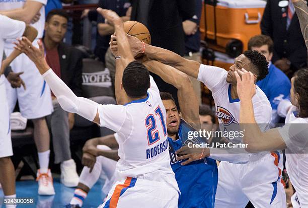 Justin Anderson of the Dallas Mavericks tries to score two points as Andre Roberson of the Oklahoma City Thunder and Russell Westbrook of the...