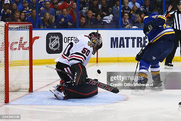 Corey Crawford of the Chicago Blackhawks makes a save against Kyle Brodziak of the St. Louis Blues in Game Seven of the Western Conference First...