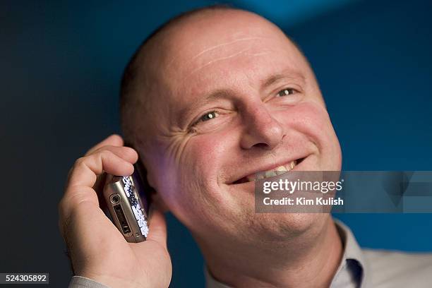 Sean Maloney, Executive Vice President and General Manager, Intel Communications Group poses with his Treo cell phone with keyboard and camera on...