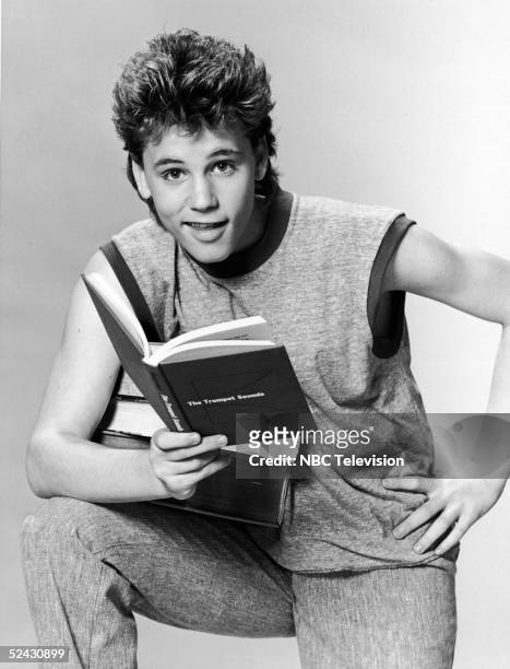 Canadian-born actor Corey Haim in character as a college student in a promotional portrait for the television series 'Roomies,' 1986. He holds open a...