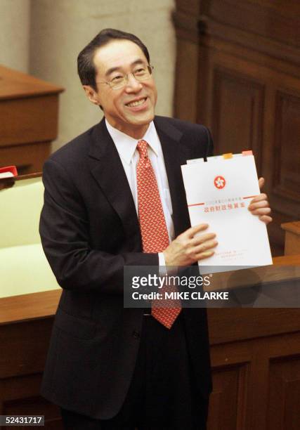 Hong Kong Financial Secretary Henry Tang holds up the budget report to members of the press inside the Legislative Council in Hong Kong, 16 March...