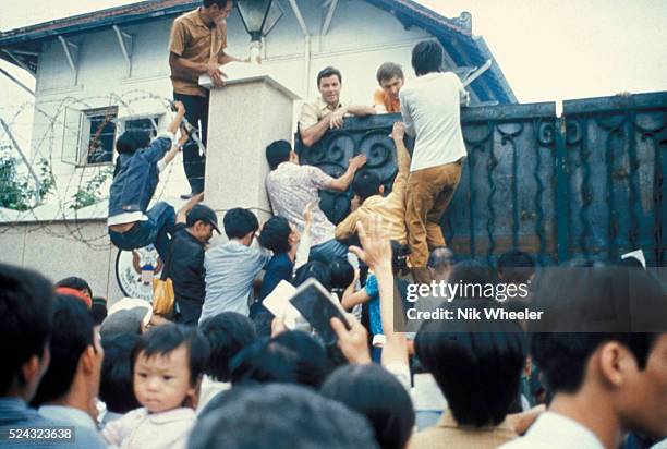 Desperate South Vietnamese citizens try to scale the walls of the American Embassy in a vain attempt to flee Saigon and avancing North Vietnamese...