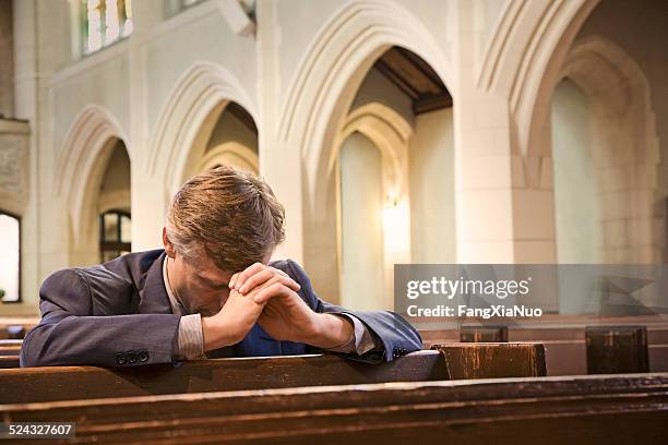 man kneeling and praying in church - confession religion stock pictures, royalty-free photos & images