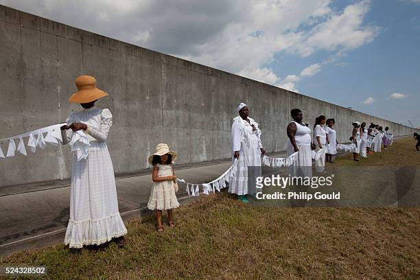 Women demonstrate in front of the Industrial Canal Wall facing the Ninth Ward on the tenth anniversary of Hurricane Katrina