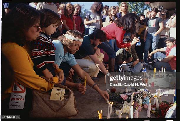 Mourners offer tributes of flowers and candles after the murder of John Lennon.