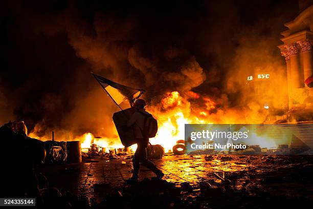 Anti-government protesters clash with the police during their storm of the Independence Square in Kiev on February 18, 2014. Flames engulfed the main...