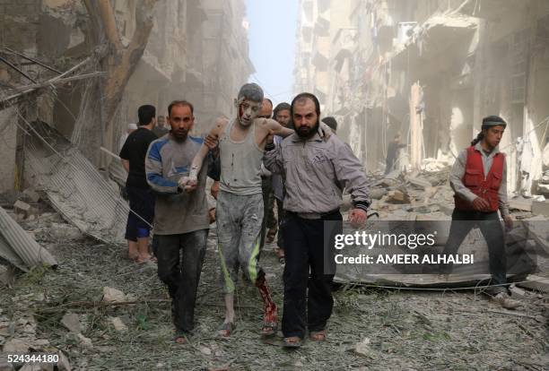 Syrians help a wounded youth following an air strike on the Fardous rebel held neighbourhood of the northern Syrian city of Aleppo on April 26, 2016.