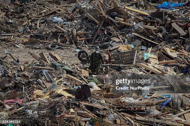 In this file photo, taken on April 13 Japanese Self Defense Force members clear debris looking for bodies in Senday, Miyagi Prefecture, on April 13,...