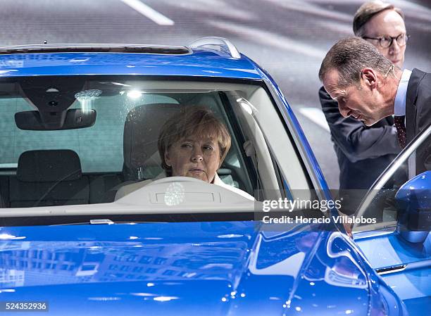 German Chancellor Angela Merkel checks out a Tiguan at Volkwagen's pavilion on the opening day of the 66th International Auto Show, in Frankfurt,...