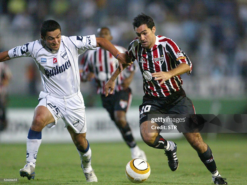 Andres Perez (D), de Quilmes, disputa la