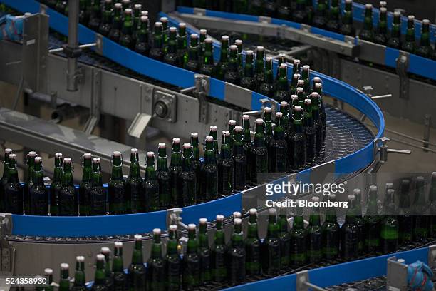 Swing top lids sit on green bottles of Grolsch beer as they move along a conveyor inside the Grolsch brewery, operated by SABMiller Plc, in Enschede,...