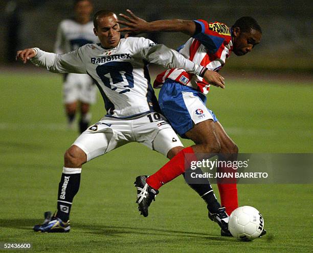 Ismael Iniguez of the Pumas of Mexico disputes the ball with Jerry Palacios of the Olimpia of Honduras, during their football match in Mexico city,...