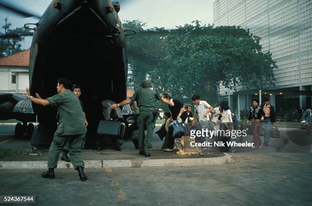 Civilians board helicopter inside the American Embassy compound in Saigon to escape advancing North Vietnamese about to capture Saigon. The evacuees...