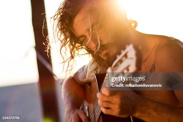 man playing guitar at the beach - amplified heat stock pictures, royalty-free photos & images