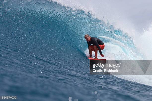 older man gets barreled on a wave in style - surf excel stock pictures, royalty-free photos & images