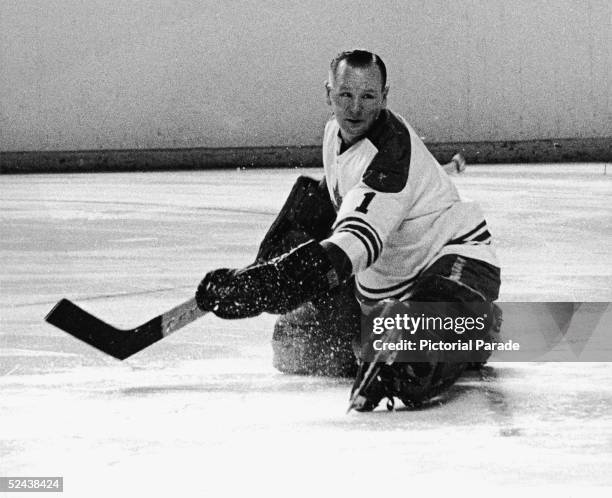 Canadian hockey player Johnny Bower, goalkeeper for the Toronto Maple Leafs, goes to the ice as he watches the puck, 1960s.