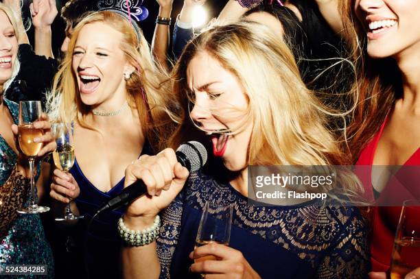 group of friends having fun on night out. karaoke. - woman party fotografías e imágenes de stock