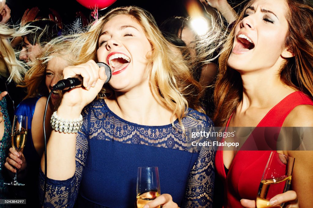 Group of friends having fun on night out. Karaoke.