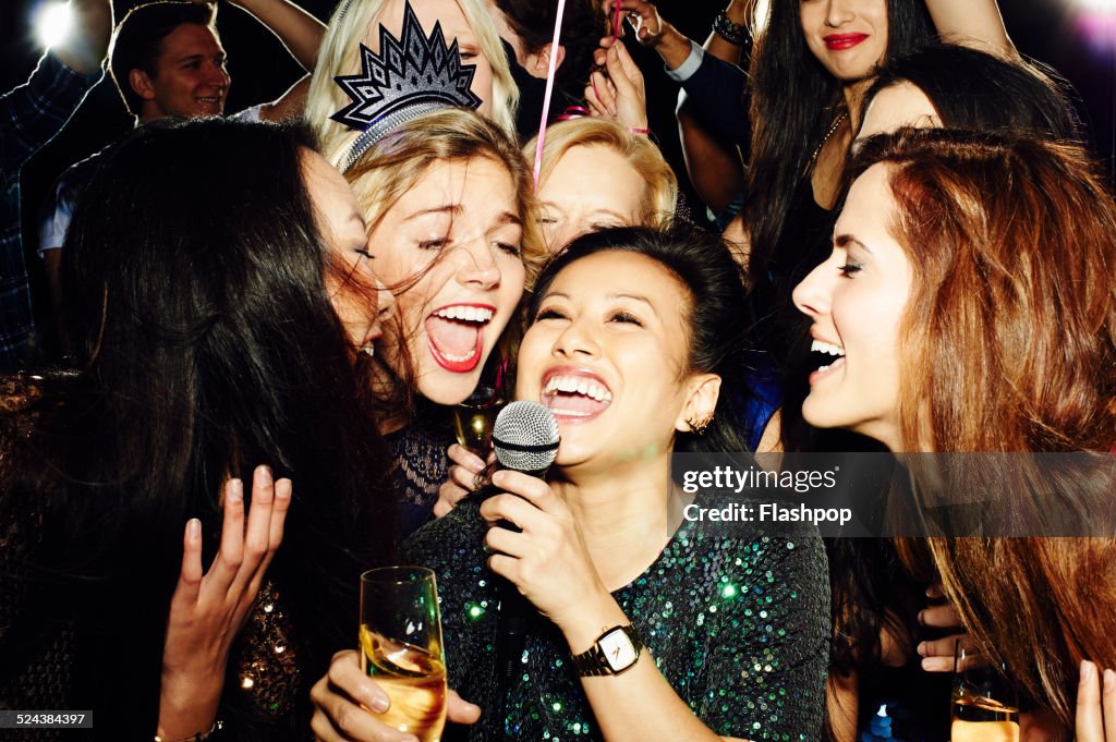 Group of friends having fun on night out. Karaoke.