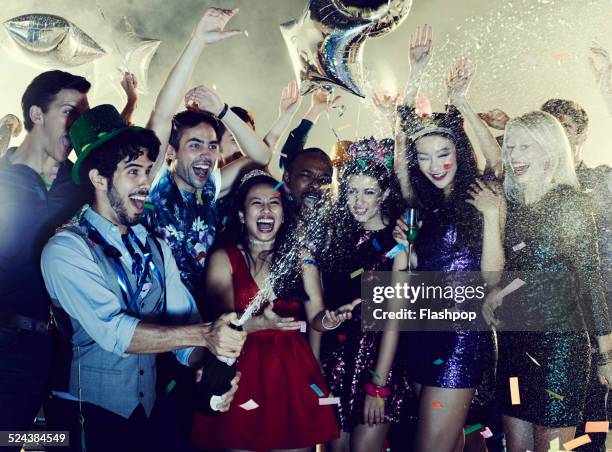 group of friends celebrating with champagne - spraying champagne stock pictures, royalty-free photos & images
