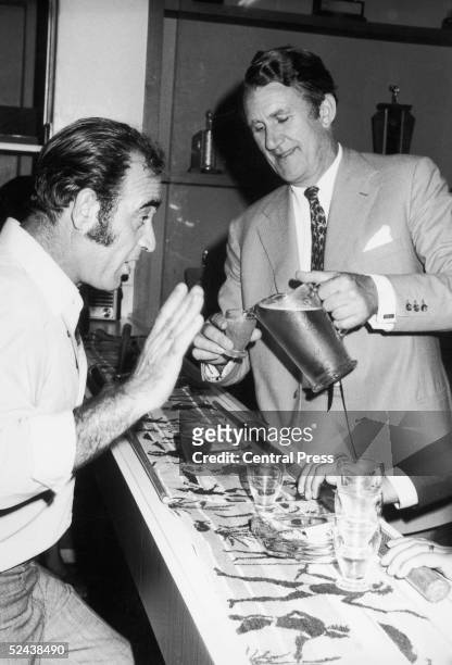 Australian Prime Minister Malcolm Fraser pouring a beer for Mario La Bianco who was protesting during Fraser's visit to the Italian Club in Perth,...