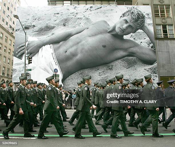 Military marching group walks past a gaint Abercrombie and Fitch billboard along 5th Avenue during the 244th New York City St. Patrick's Day Parade...