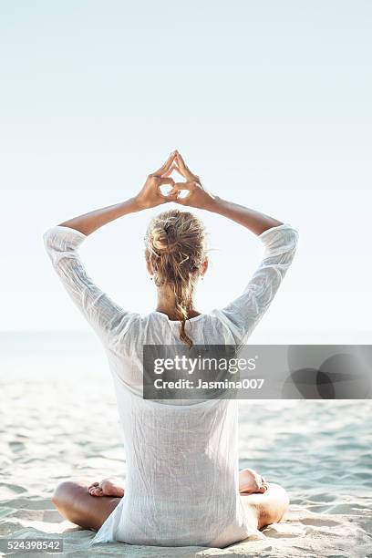 young woman sitting on the beach and meditating - mudra stock pictures, royalty-free photos & images