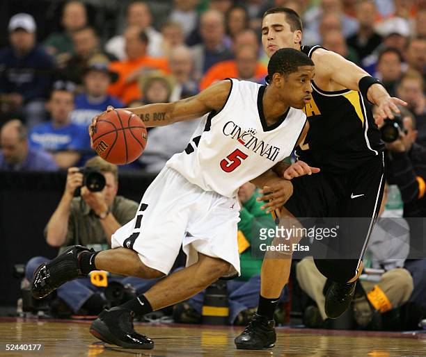 Nick Williams of the Cincinnati Bearcats drives against Jeff Horner of the Iowa Hawkeyes in the first round game of the NCAA Division I Men's...