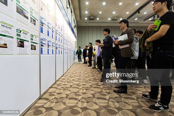 Jobseekers look at listings displayed at a job fair in Goyang, South Korea, on Tuesday, April 26, 2016. South Korea's economy slowed in the first...