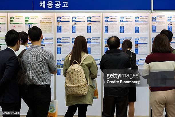 Jobseekers look at listings displayed at a job fair in Goyang, South Korea, on Tuesday, April 26, 2016. South Korea's economy slowed in the first...