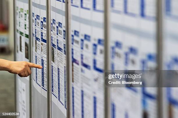 Jobseeker points at listings displayed at a job fair in Goyang, South Korea, on Tuesday, April 26, 2016. South Korea's economy slowed in the first...