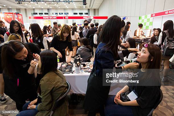 Jobseekers have makeup applied at a booth at a job fair in Goyang, South Korea, on Tuesday, April 26, 2016. South Korea's economy slowed in the first...